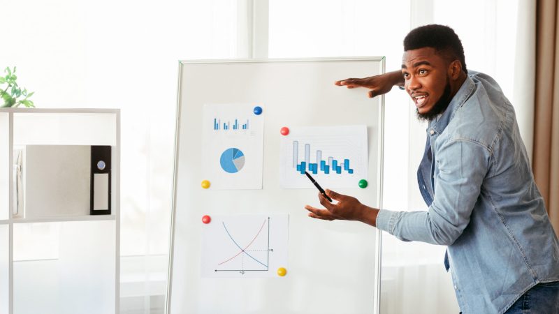 New business strategy. Confident african american top manager presenting company development plan to colleagues in modern office.